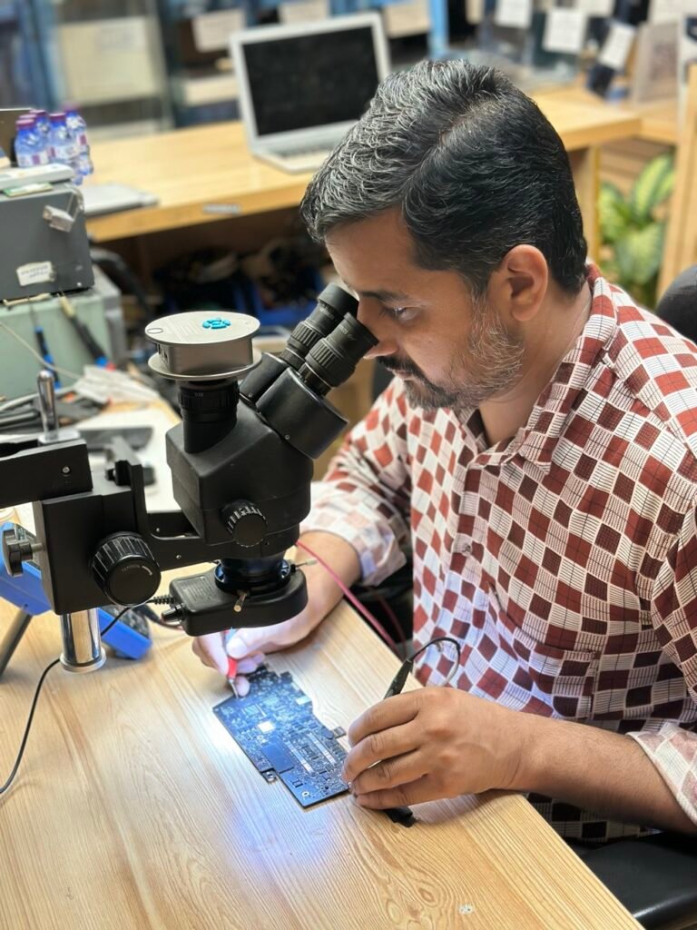 Two Mak Doctor technicians working on one logic board