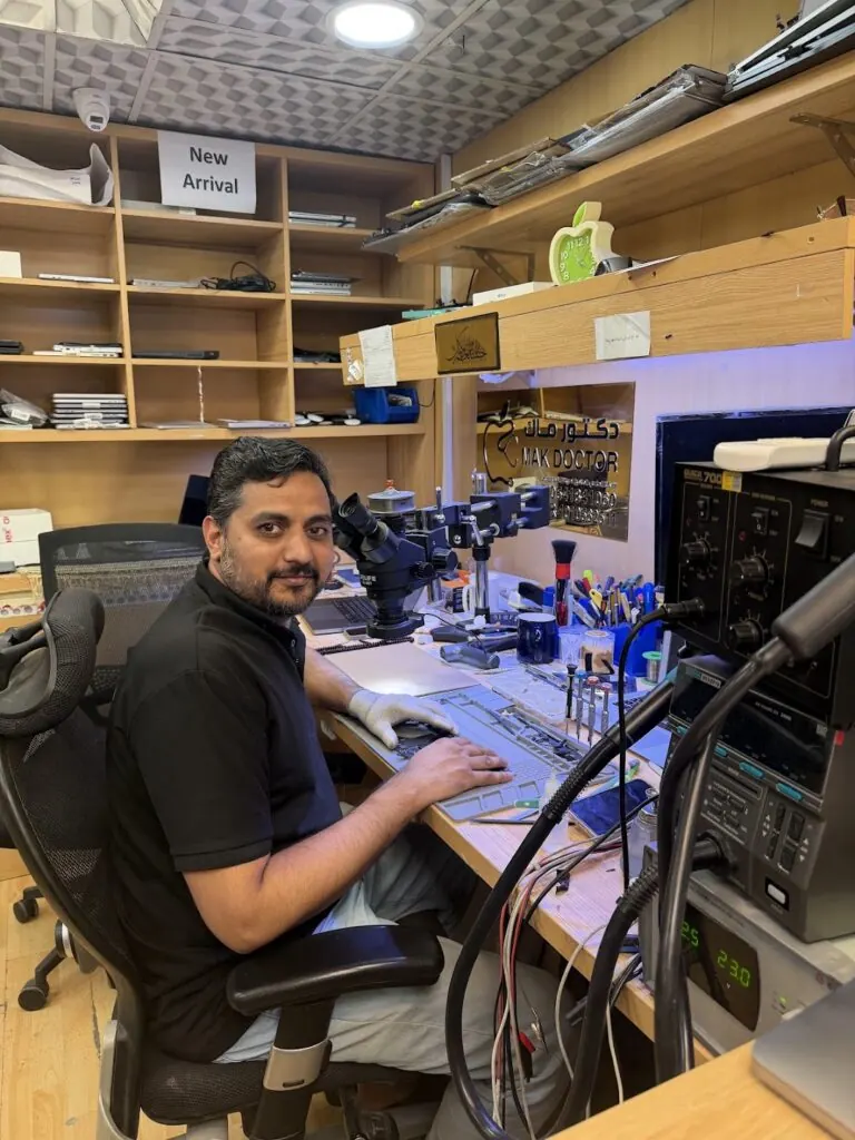 Mak Doctor technician repairing a MacBook at the Olaya workshop bench